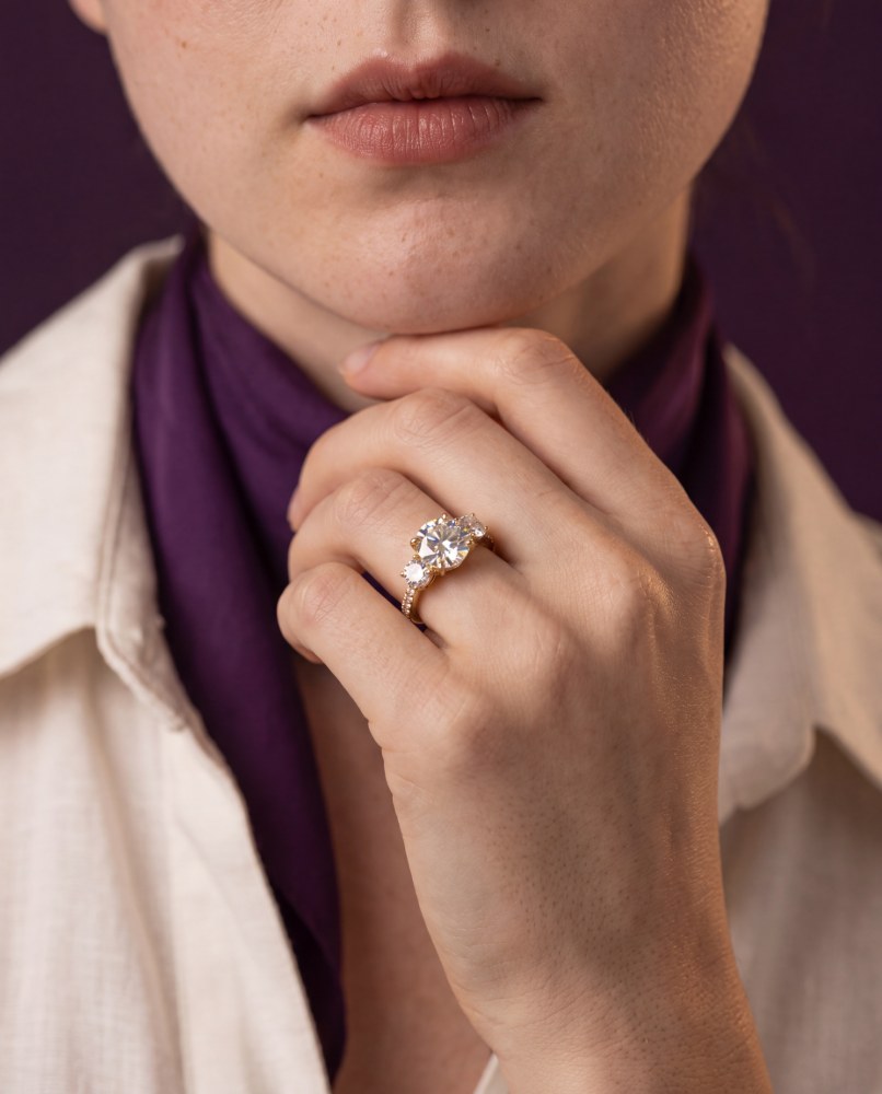 Starry pavé ring worn on a hand resting at the chin
