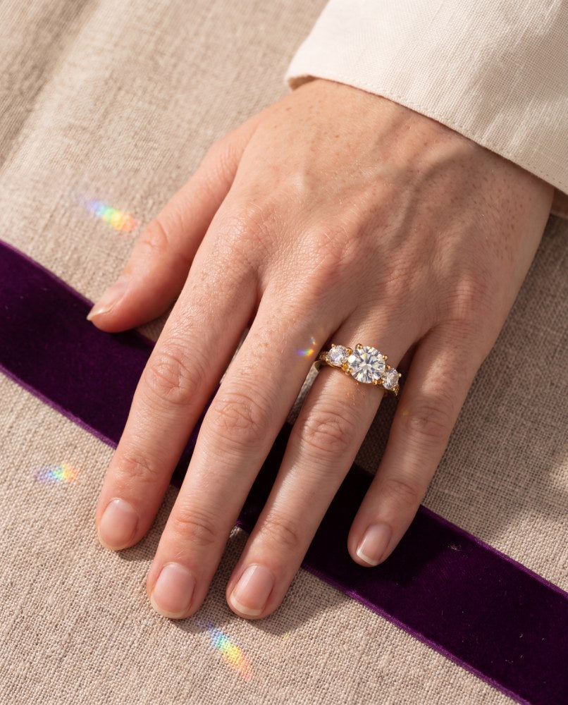 Starry pavé ring worn on a hand against linen